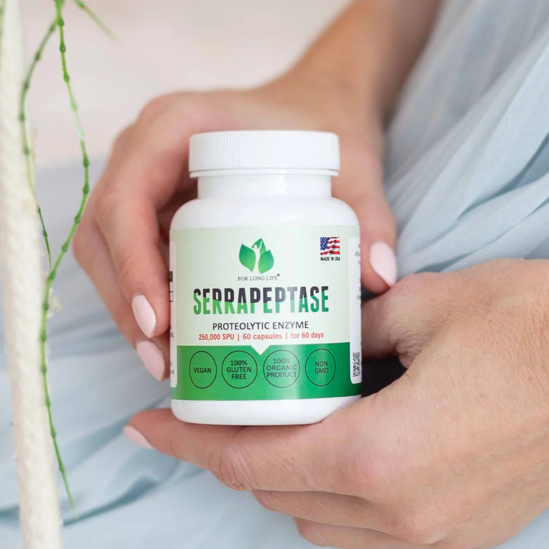 Ruce_co _drží_Serrapeptáza_250000 SPU_ proteolyticky_enzym_ bílá_dóza_na_bílém_pozadí_for_long_life_linie4life
