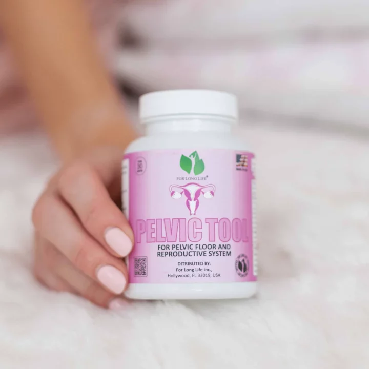 Doplněk stravy Pelvic Tool pro zdraví pánevního dna a reprodukčního systému, bílá nádoba na ruce s jemnými nehty.