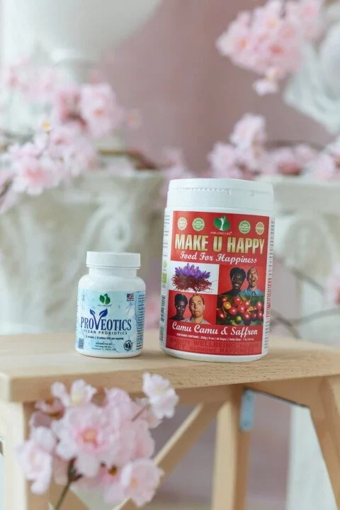 Dvě láhve doplňků stravy na stolku s květinovou dekorací, propagace zdraví a štěstí pro každodenní pohodu.