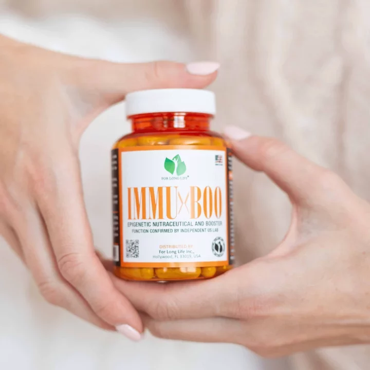 Lahev vitamínových doplňků IMMUxBOO v ruce, podporující imunitu s epigenetickou formulí, pro dlouhý život.