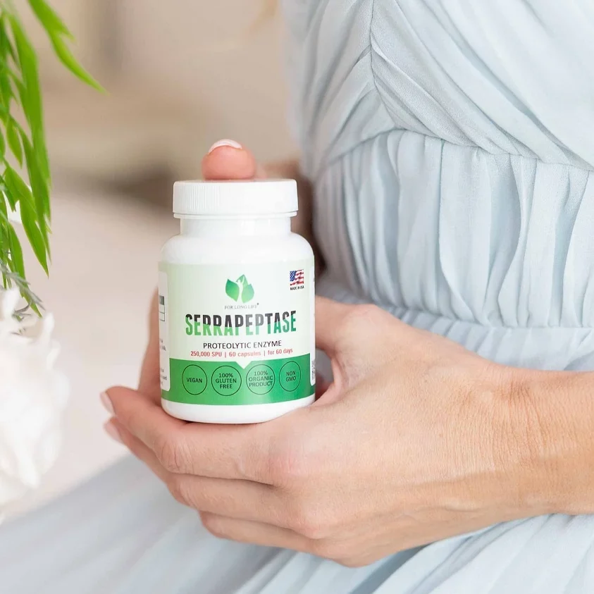 Žena držící lahvičku s doplňkem stravy Serrapeptase, proteolytickým enzymem, vhodným pro vegany a bez lepku.