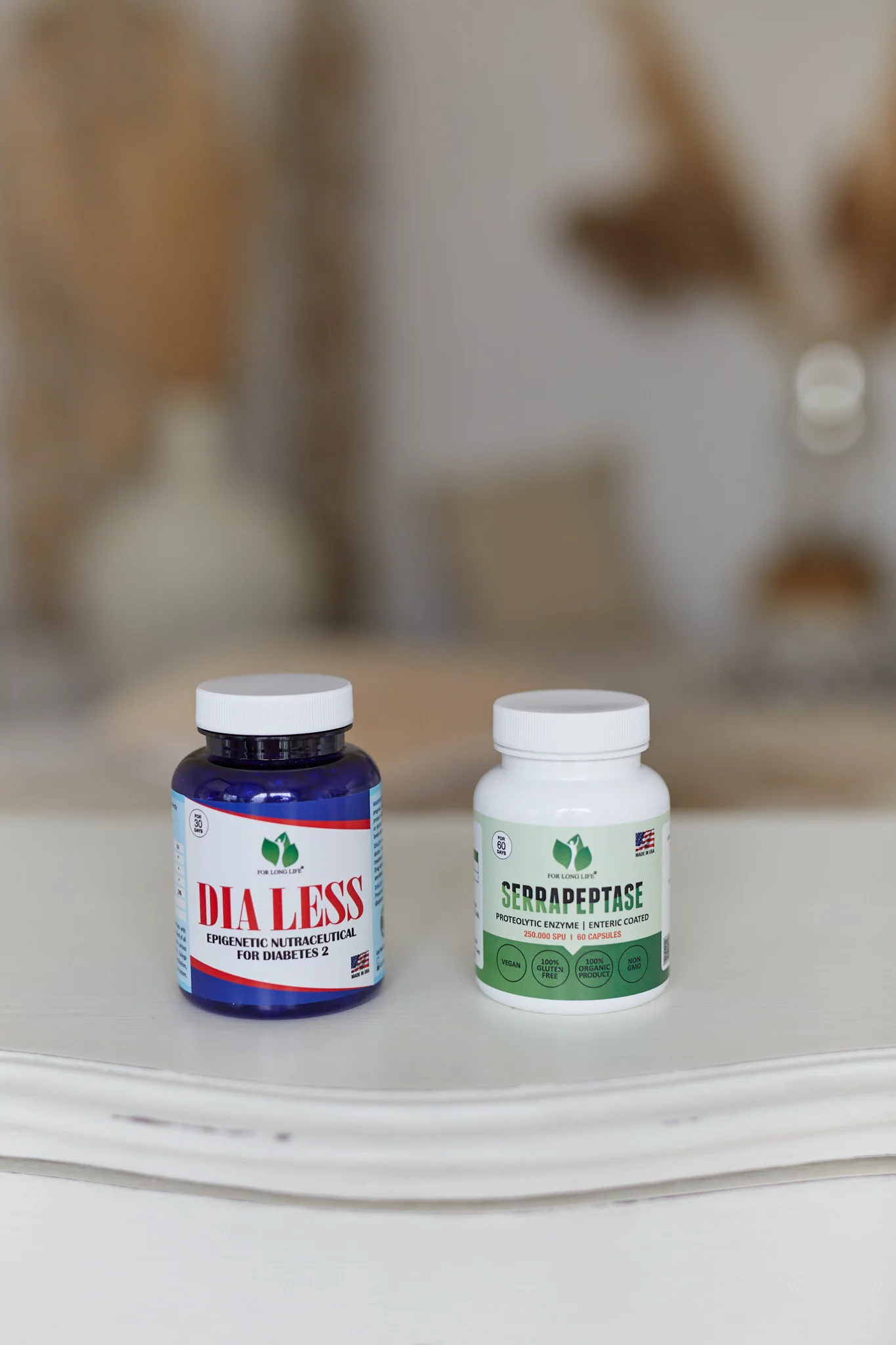 Dvě lahvičky doplňků stravy na bílém povrchu „DIA LESS“ pro podporu diabetu a „SERAPEPTASE“ pro výhody proteolytických enzymů.